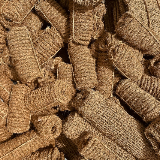 Coconut fiber rope prepared for wrapping around shade sail hardware in an outdoor setting.